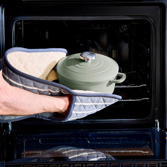 someone putting green caserole into oven