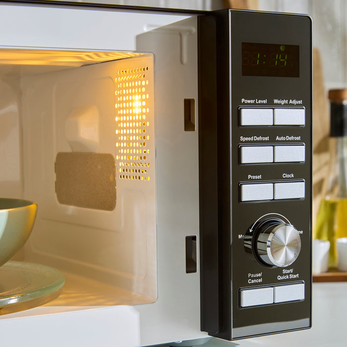 Close-up of a microwave oven with digital display and control panel.