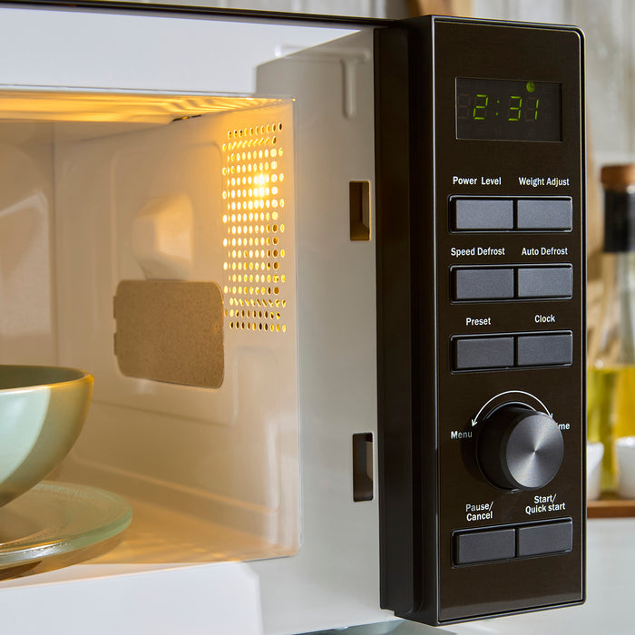 Close-up of a microwave oven with digital display and control panel.