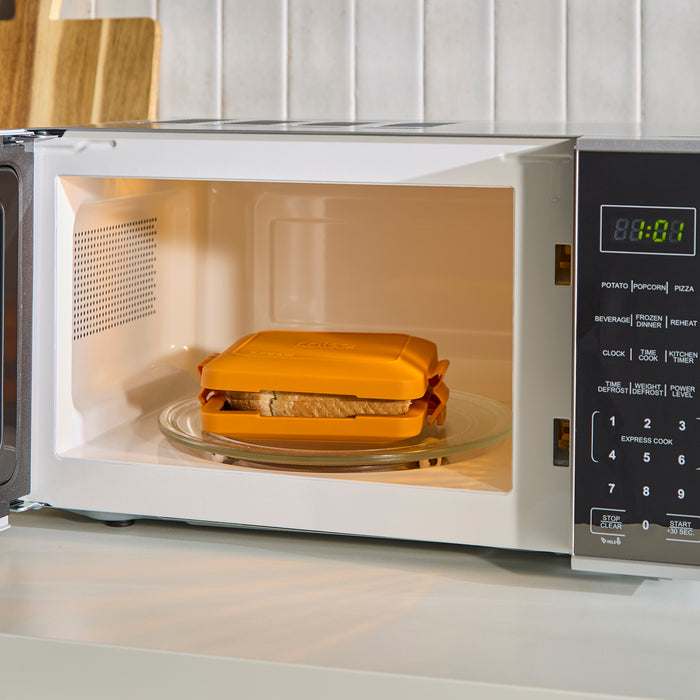 Toastie Maker inside a microwave oven on a kitchen counter.
