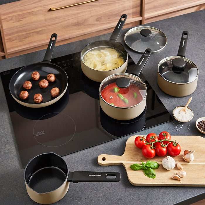 Cooking scene with pots, pans, and ingredients on a stovetop and countertop.