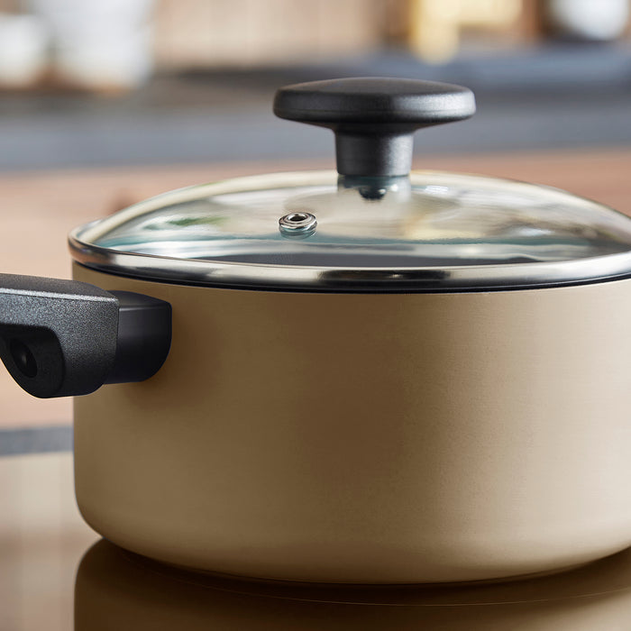 Beige pot with a black handle and lid on a neutral background