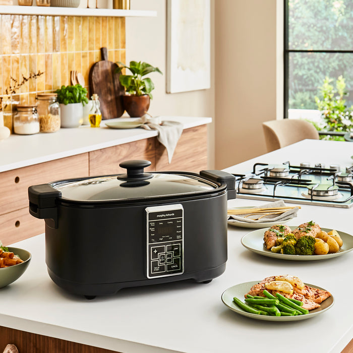 multi cooker on a kitchen counter with food placed around it