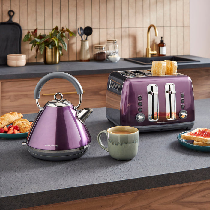 Purple kettle and toaster on a kitchen counter with a cup of coffee and toast.