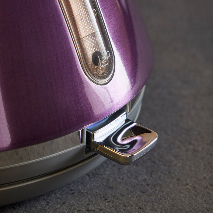 Close-up of a purple kettle with a metallic base on a dark surface