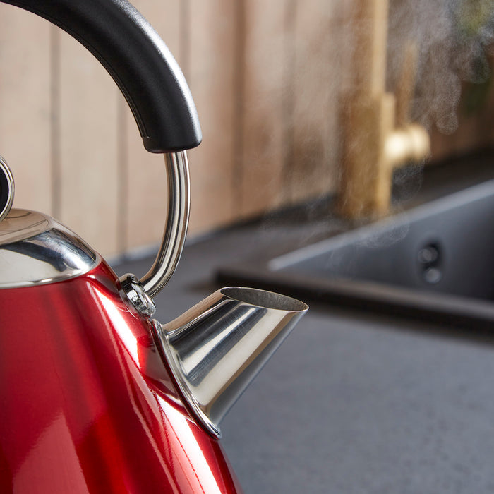 Red kettle with steam rising in a kitchen setting