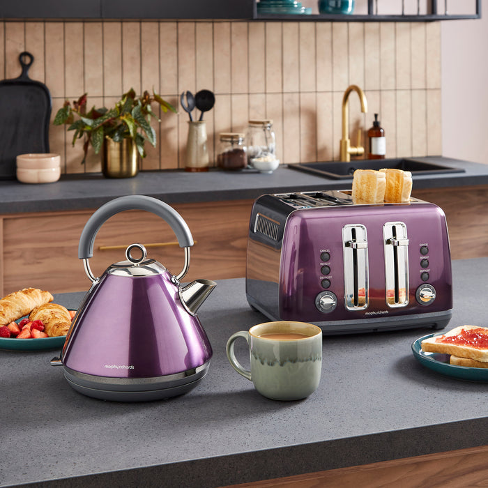 Purple kettle and toaster on a kitchen counter with toast and a mug.