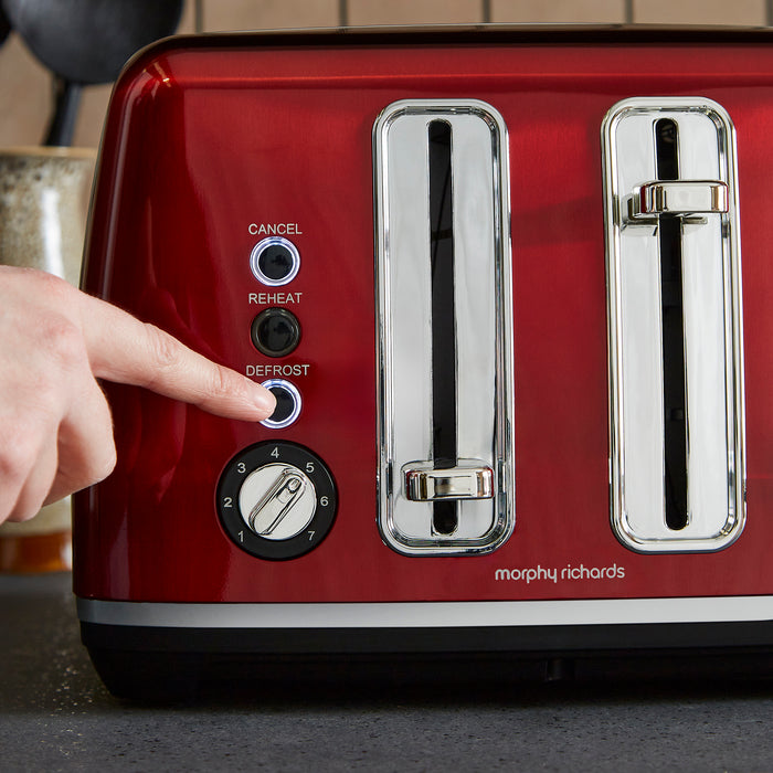 Red Morphy Richards toaster with a hand pressing a button