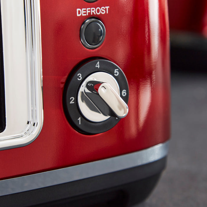 Red toaster with control knob and 'DEFROST' button on a blurred background