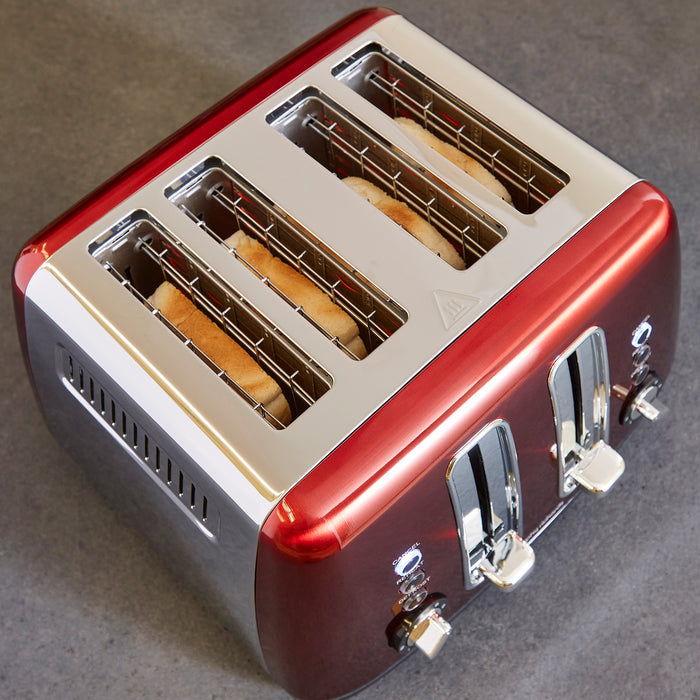Red and silver toaster with slices of bread on a gray background