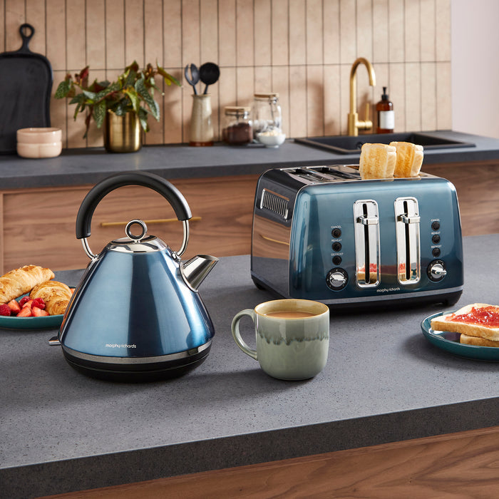 Blue kettle and toaster on a kitchen counter with a cup of coffee and breakfast items.