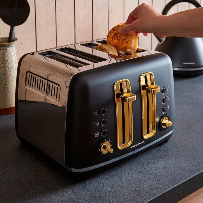 Black toaster with gold accents being used in a kitchen setting