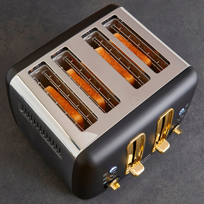 Modern toaster with four slices of bread in the slots on a dark background