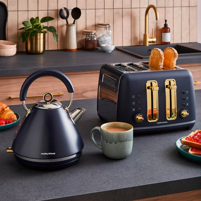 Kitchen counter with a blue kettle, toaster, and coffee cup on a wooden kitchen background.