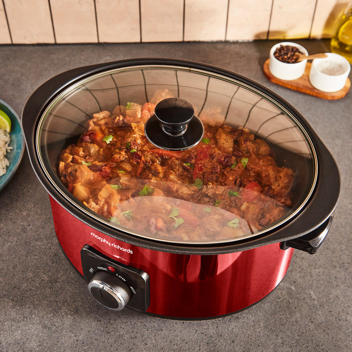 Red Morphy Richards slow cooker with food inside on a kitchen counter