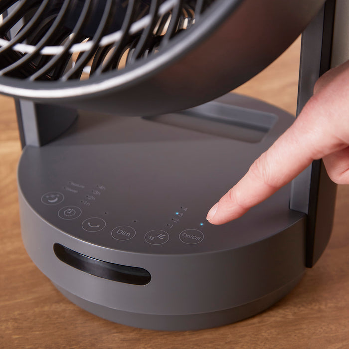 person pressing buttons on desktop fan