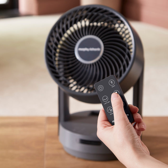 grey fan with person holding a remote control
