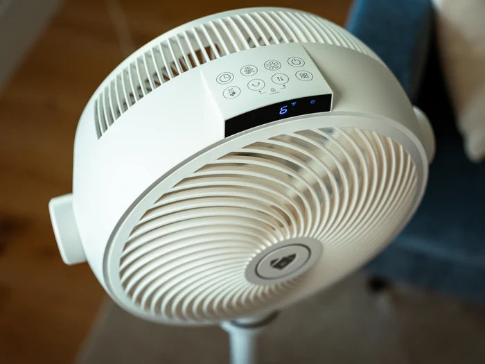 White oscillating Airdog fan with digital display on a blurred background