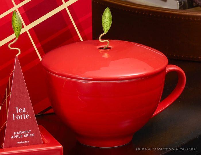 MAIN PDP | Ruby Red Café Cup with cover closed next to other Warming Joy items