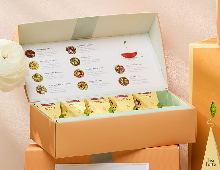 Herbal tea assortment in a 10 count petite presentation box with lid open, around other Herbal boxes