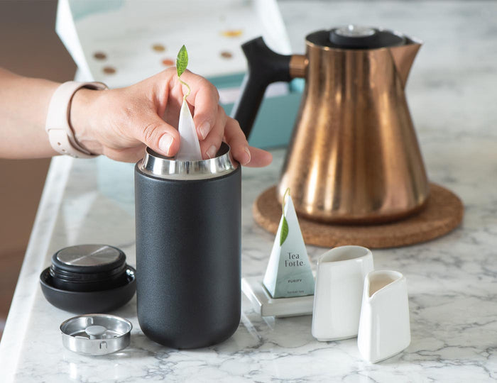 MAIN PDP | Carter Move travel mug in black with stainless steel infuser on table