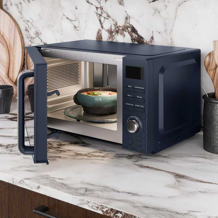 Black microwave oven on a marble countertop with a bowl inside