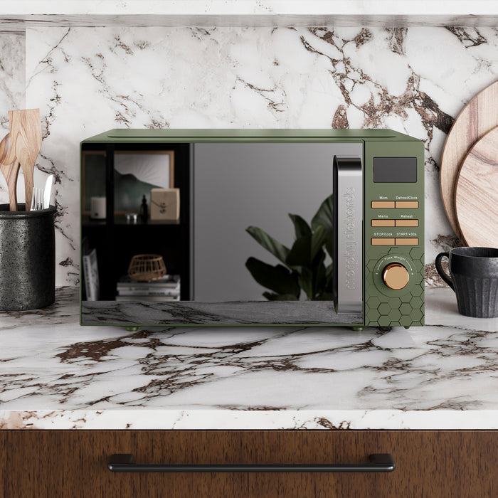 Green microwave oven on a marble countertop with a kitchen setting.
