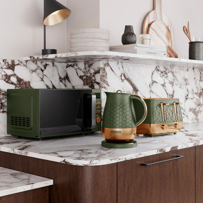 Green microwave, kettle, and toaster on a marble countertop with a shelf in the background.