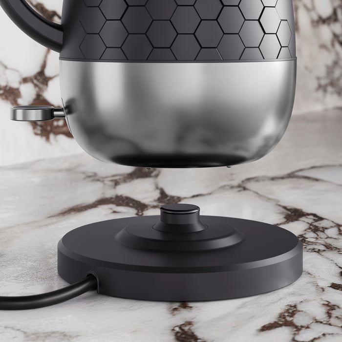 Black kettle hovering over heated base plate.