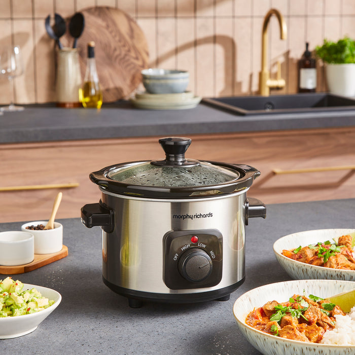Morphy Richards slow cooker on a kitchen counter with food and utensils in the background
