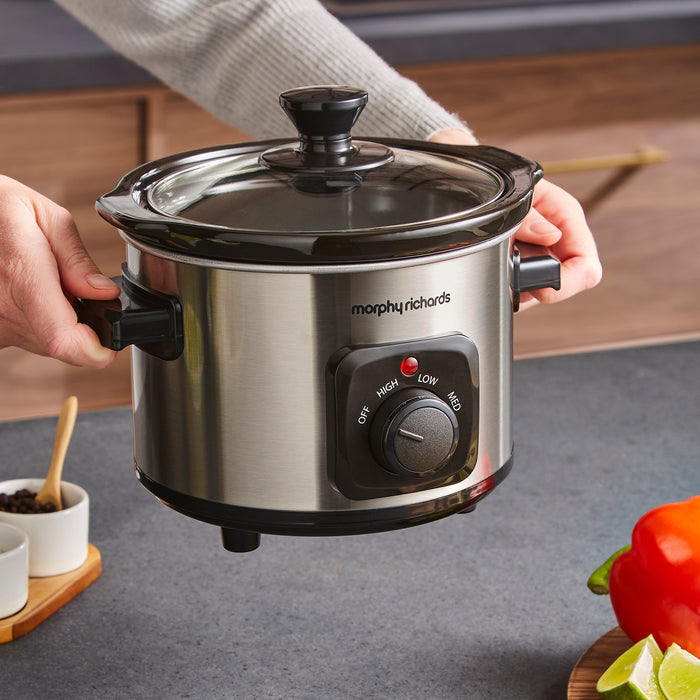 Morphy Richards slow cooker held by a person in a kitchen setting