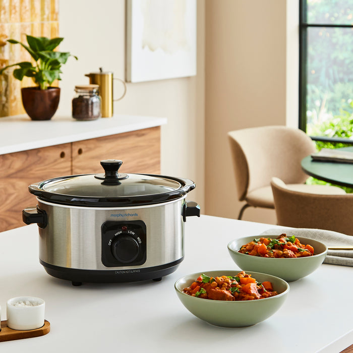 slow cooker on kitchen countr with bowls of food placed around it