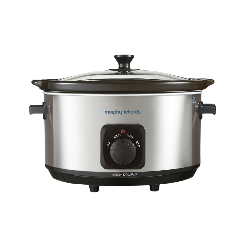 A Morphy Richards stainless steel 6.5L slow cooker with a black glass lid and brushed stainless steel body, featuring a control knob on the front.