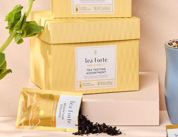 Single Steeps tea assortment in a 30count chest of Single Steeps pouches with lid closed and one pouch spilling out tea