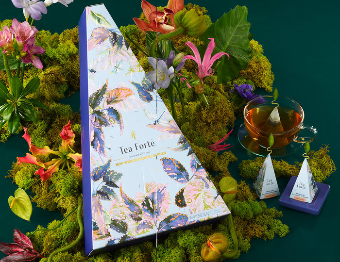 MAIN PDP | Demoiselle 12 days of Teas box with a teacup and tea infusers in a layer of moss and flowers