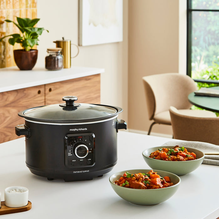 slow cooker on kitchen counter with stew in bowls