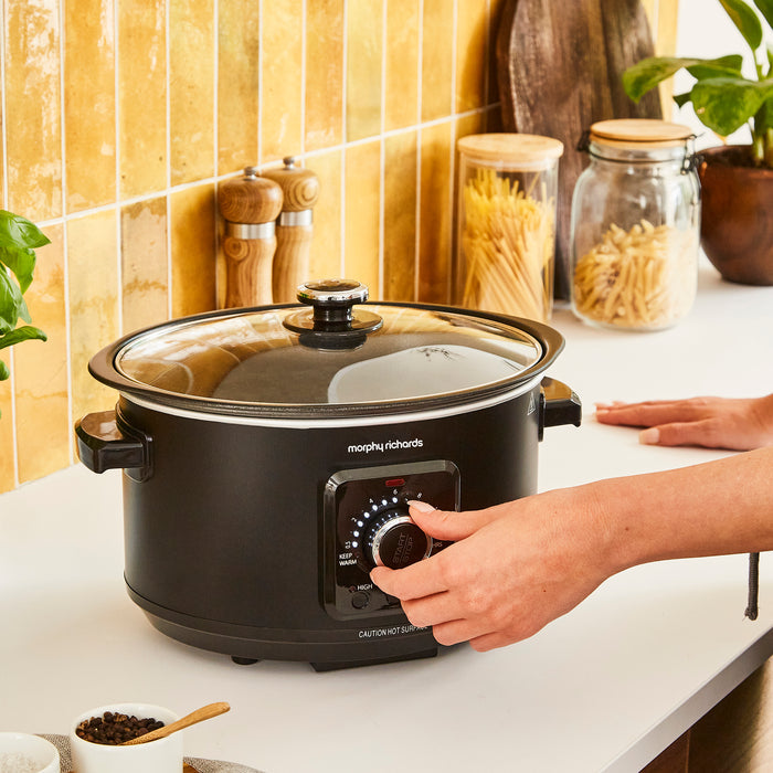 someone turning the timer dial on slow cooker