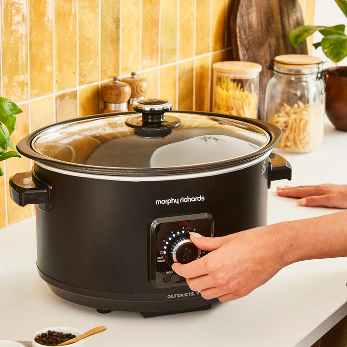 someone turning slow cooker dial