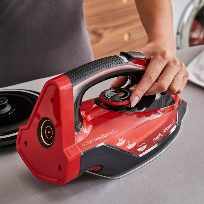 Red and black iron with 'Morphy Richards' branding on a gray surface.