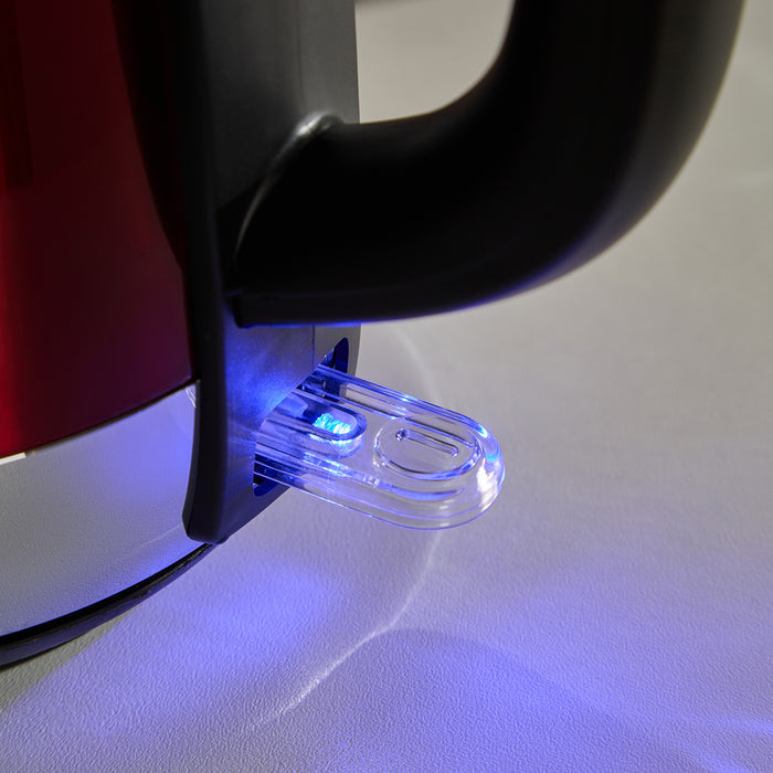 Close-up of a red electric kettle with a blue light on a white surface