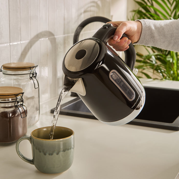 Kettle pouring the boiling water into a mug