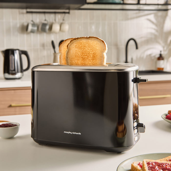 Black toaster with slices of toast on a kitchen counter