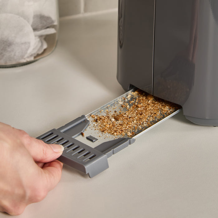 Person removing a crumb tray from a toaster