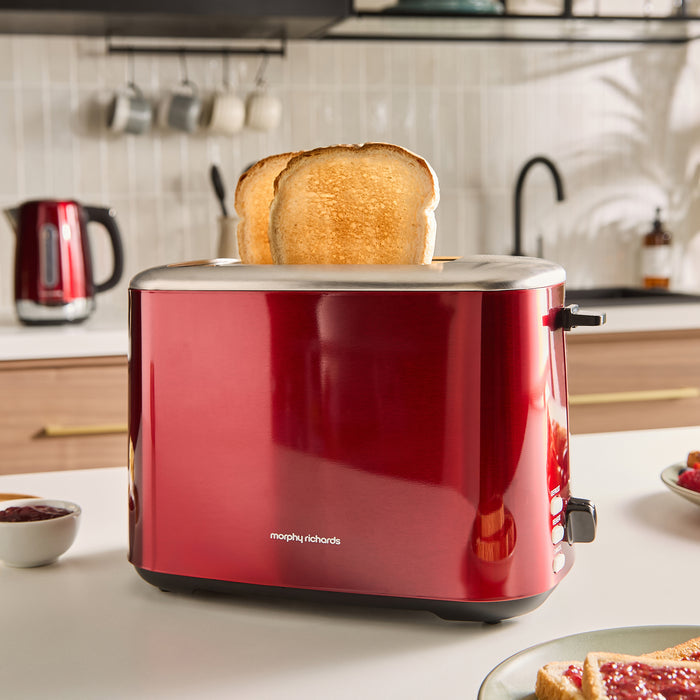 Red toaster with a slice of toast on a kitchen counter