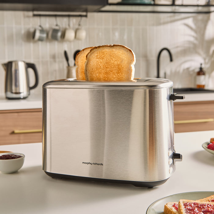 Stainless steel toaster with bread on a kitchen counter