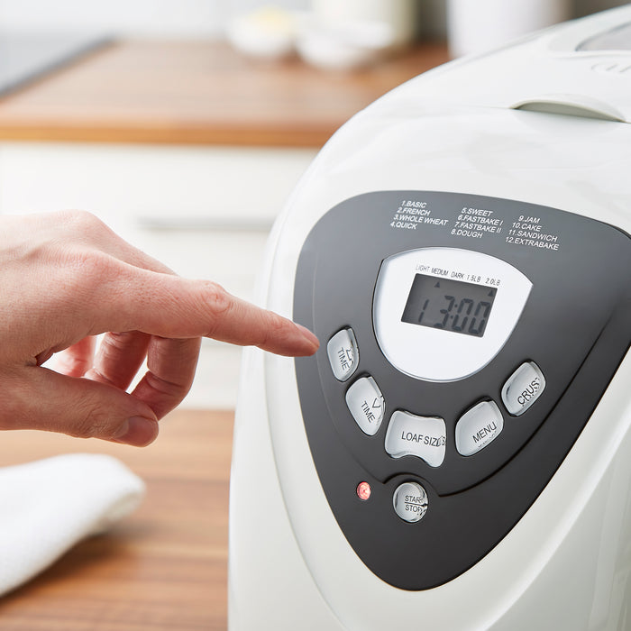 somone pressing a button on a breadmaker