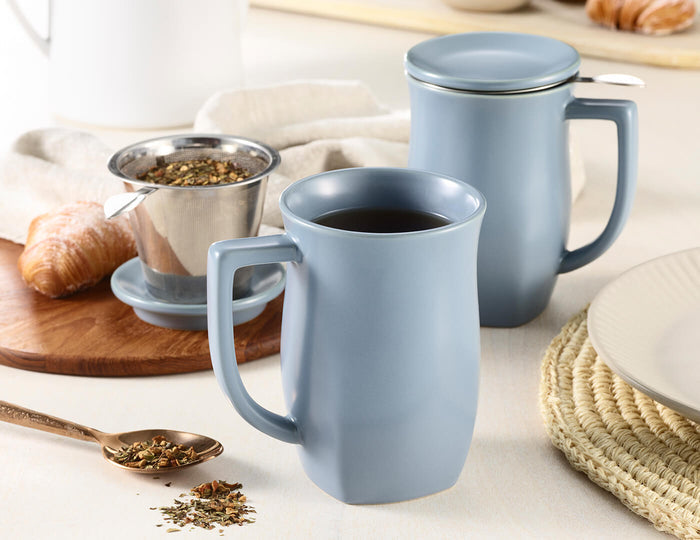 MAIN PDP | Fiore Steeping Cup and infuser in Stone Blue on a table with tea and croissants
