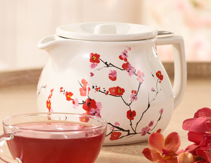 MAIN PDP | Fiore Sakura Teapot with lid on table with glass cup of tea