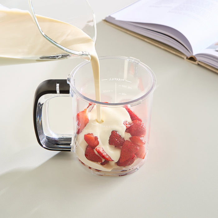 person adding strawberries and cream mixture to a cansiter