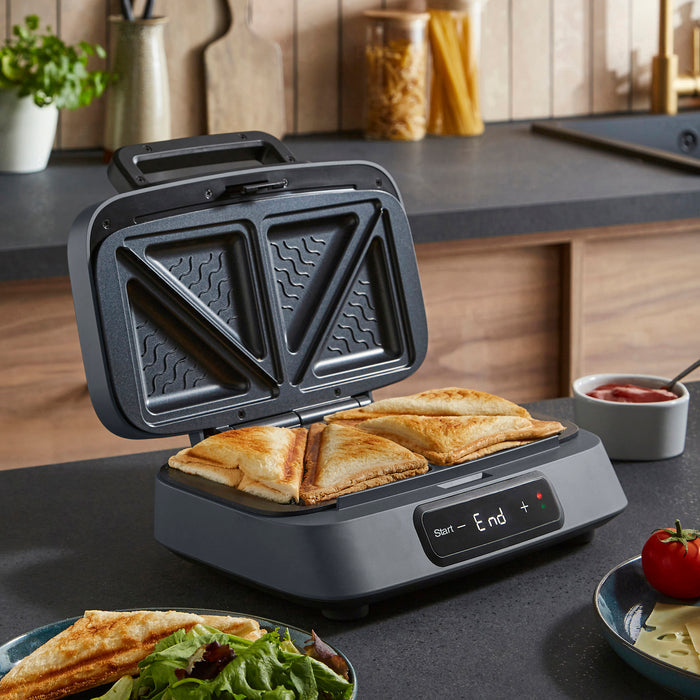 sandwich maker with toasted sandwiches on a kitchen counter